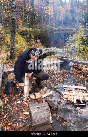 Finnland; Karhunkierros Trail - der große Bär-Trail Wandern in Lappland, ein Wanderer Schneiden von Holz im Herbst im Oulanka National Park Stockfoto