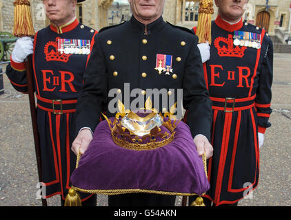 Pageantmaster der Queen's Diamond Jubilee Beacons Bruno Peek (Mitte) mit dem Jubilee Crystal Diamond, am Tower of London, im Zentrum von London, wo der Kristall bis zum Diamantenjubiläum von Queen Elizabeth II. Aufbewahrt werden soll. Stockfoto