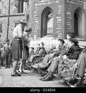 Königin Elizabeth II. Sprach mit dem 15-jährigen Jimmy Campbell, als sie während der jährlichen St. George's Day Parade der Queen's Scouts eine Gruppe von behinderten Pfadfinderinnen im Schloss Windsor traf. Stockfoto