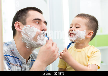 glückliches Kind viel Spaß mit Papa rasieren im Bad Stockfoto