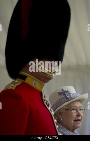 Königin Elizabeth II. Steht mit einem Offizier, während sie eine Zeremonie ansieht, in der sie dem 1. Bataillon und der 7. Kompanie der Coldstream Guards in Windsor Castle neue Farben überreichte. Stockfoto