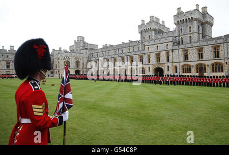 Mitglieder des 1. Bataillons und der No. 7 Company, die Coldstream Guards, werden zur Inspektion anstehen, bevor sie von Königin Elizabeth II. Mit ihren neuen Farben präsentiert werden, bevor sie im Windsor Castle im Windsor Castle präsentiert werden. Stockfoto