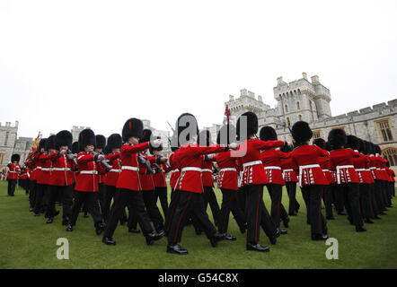 Mitglieder des 1. Bataillons und der No. 7 Company, die Coldstream Guards, werden zur Inspektion anstehen, bevor sie von Königin Elizabeth II. Mit ihren neuen Farben präsentiert werden, bevor sie im Windsor Castle im Windsor Castle präsentiert werden. Stockfoto