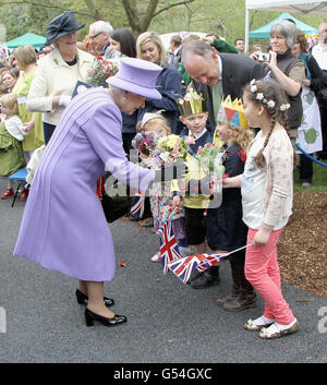 Königin Elizabeth II. Wird bei einem Besuch im Nine Springs Park in Yeovil mit Blumen überreicht. Stockfoto