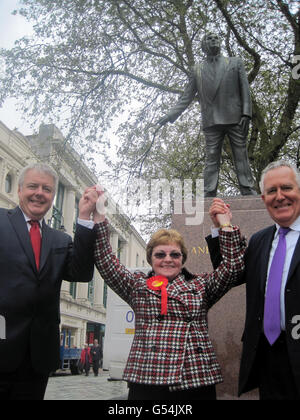 (Von links nach rechts) die erste Ministerin Carwyn Jones, die Ratsvorsitzende von Cardiff Heather Joyce und der Sekretär von Shadow Wales, Peter Hain, feiern den Wahlsieg der Partei in der walisischen Hauptstadt durch die Statue von Anerin Bevan in der Queen Street, Cardiff. Stockfoto