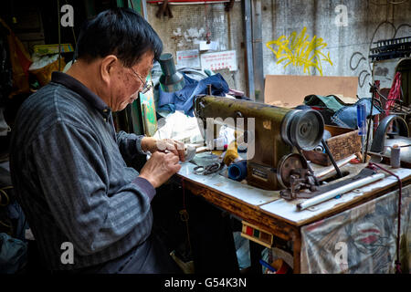 Ein Schneider bei der Arbeit in seinem Stall in der Nähe von Graham Street in Central, Hongkong am 25. März 2014. Stockfoto