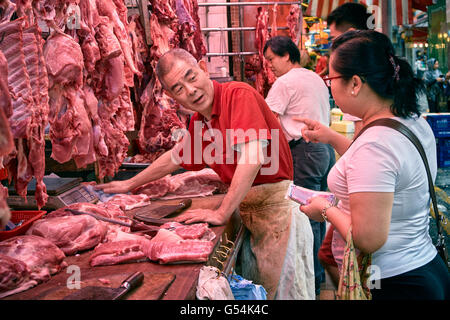 Ein Schwein Metzger bereitet einen Auftrag für einen Kunden in seinem Stall auf Bowrington Straße in Causeway Bay, Hong Kong. Stockfoto