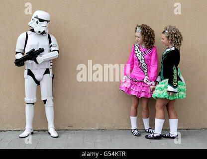 Sarah Duggan, 13, (links) und Shannon Tone, 14, üben den irischen Tanz neben einem Mann, der als Storm Trooper aus dem Film Star Wars gekleidet ist, während sie sich heute auf der Citywest Convention in Dublin treffen. Für die Invasion Dublin Star Wars Convention und die Irish Dancing Open Championships, die beide an diesem Wochenende stattfinden. Stockfoto