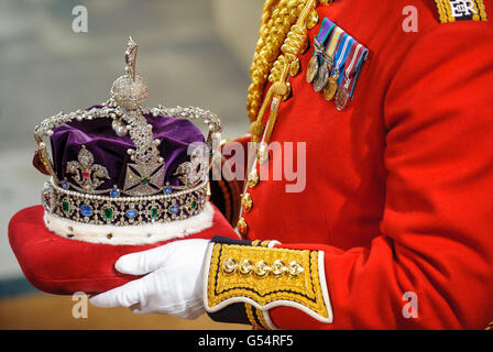 Die Imperial State Crown wird von den Houses of Parliament in Westminster, im Zentrum von London, nach der Eröffnung des Parlaments durch den Staat getragen. Stockfoto