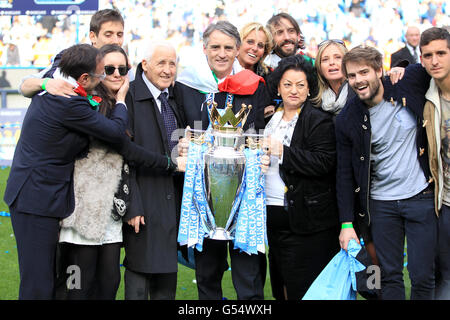 Manchester City Manager Roberto Mancini (Mitte), mit einer italienischen Flagge gehüllt, feiert mit seinem Vater Aldo (4. Links), seiner Frau Federica (6. Rechts) und seiner Mutter Marianna (4. Rechts) die Barclays Premier League Trophy Stockfoto