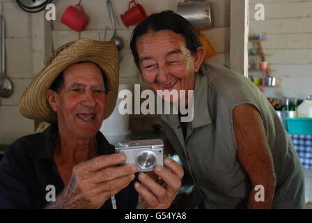 Eine kubanische Tabakbauern in Vinales und seine Frau lachen, als sie ein Bild von sich selbst auf einer Canon-Kamera anzeigen Stockfoto