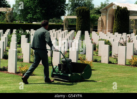 COMMONWEALTH-KRIEGSGRÄBER: Ein Gärtner mäht die Rasenflächen auf dem britischen Militärfriedhof in Bayeux, Normandie. Der Friedhof wird von der Königin am 50. Jahrestag der D-Day Landings vom Juni 1944 besucht werden. Die Normandie war während des Zweiten Weltkriegs Schauplatz heftiger Kämpfe zwischen alliierten und deutschen Streitkräften. * 11/11/2000 Gärtner mähen die Rasenflächen auf dem britischen Militärfriedhof in Bayeux, Normandie. Drohende Lohnkürzungen für Gärtner, die britische Kriegsgräber im Ausland hüten, wurden ausgesetzt, während eine Überprüfung der Zulagen durchgeführt wird, wurde am Samstag, dem 11. November 2000, bestätigt. Der Umzug ist ein Stockfoto