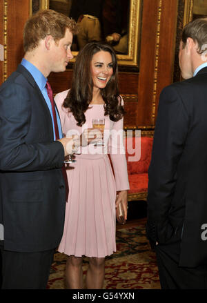 Der Herzog und die Herzogin von Cambridge spricht mit Prinz Harry vor einem Empfang in der Waterloo Kammer, vor ihrem Jubilee Lunch der Souveränen Monarchen im Schloss Windsor. Stockfoto