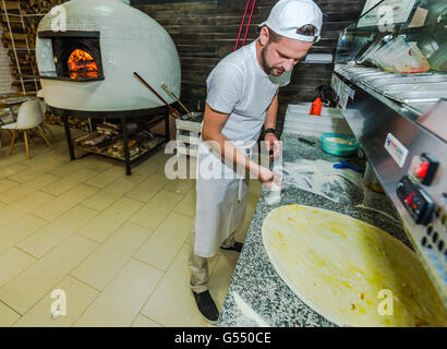 Junge Professinal bärtigen Pizzabacken im traditionellen Restaurant Koch Stockfoto