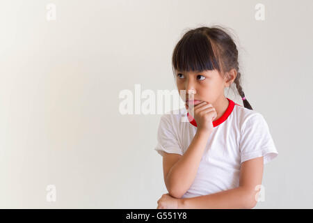 Asiatische Mädchen Kind ist etwas denken. Stockfoto