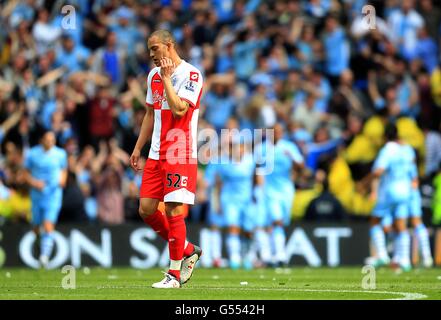 Fußball - Barclays Premier League - Manchester City / Queens Park Rangers - Etihad Stadium. Bobby Zamora von Queens Park Rangers ist niedergeschlagen, als Manchester City das Eröffnungziel feiert Stockfoto