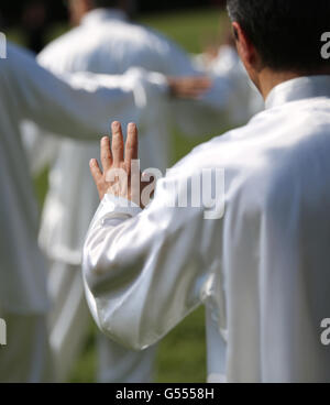 Hand der Meister der Kampfkunst Tai Chi während der Ausstellung im öffentlichen Park mit Anhänger Stockfoto