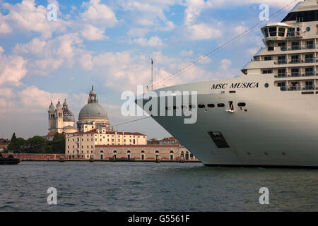 Ein riesiges Kreuzfahrtschiff im Bacino di San Marco Zwerge der Dorsoduro Uferpromenade und der Santa Maria della Salute, Venedig, Italien Stockfoto