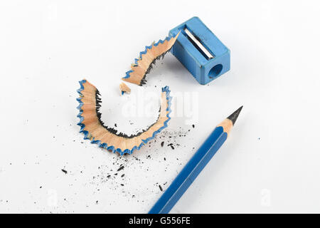 Enge Fokussierung auf schärfen blauen Stift neben Bleistiftspitzer und Späne auf weißem Papier Stockfoto
