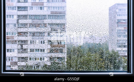 Stadtansicht aus dem verregneten Fenster. Regentropfen auf das Fenster Stockfoto