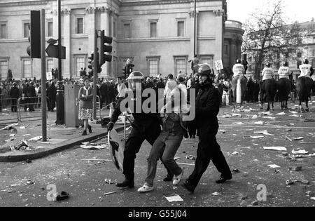 Polizeibeamte in Bereitschaftskleidung verhaften einen Protestierenden in der Nähe der National Gallery, Trafalgar Square, London, nachdem sich eine Demonstration gegen die Abgabensteuer zu einem Aufruhr entwickelt hatte. Berittene Offiziere können im Hintergrund gesehen werden, Blick auf Charing Cross Rd. Stockfoto