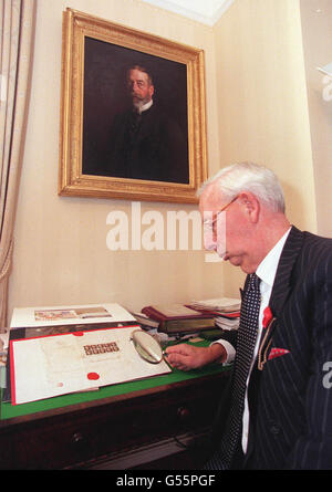 Charles Goodwyn, Keeper der Royal Philately Collection im St. James's Palace in London, der einen Einband für den ersten Tag mit zehn Exemplaren der Penny Black, der weltweit ersten Briefmarke, die am 6. Mai 1840 verwendet wurde, erwerben soll. * der Umschlag im Wert von 250,000 wird von Stanley Gibbons Ltd gekauft und wird durch den Verkauf von überschüssigem Duplikat aus der Sammlung von King George V bei einer öffentlichen Auktion finanziert. Im Hintergrund hängt ein Porträt von König Georg V. Stockfoto