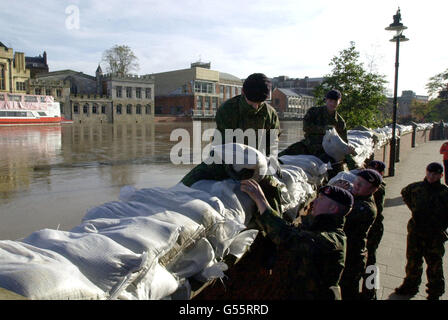 Dutzende von Soldaten helfen, die Hochwasserabwehr im Zentrum der Stadt York zu stärken. Da der Fluss Ouse immer noch gefährlich hoch ist, benutzte die Armee Sandsäcke, um die Hochwasserbarrieren zu erhöhen. Stockfoto