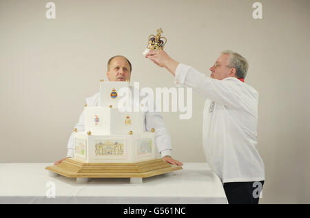 Paul Farrant (rechts), Fachlehrer, Food-Service-Flügel, Defense School of Logisitics, mit Craft Director Andrew Jones, platziert die Krone (ganz aus Zucker) auf dem Diamond Jubilee Cake im Worthy Down Camp in der Nähe von Winchester, Hampshire. Stockfoto