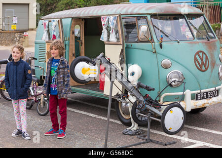 Kinder posieren vor einem alten VW Campervan, der im Juni beim Bournemouth Wheels Festival in Bournemouth, Dorset, Großbritannien, zu sehen ist Stockfoto