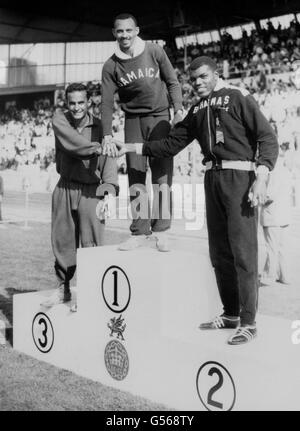 Jamaikas Keith Gardner (c) auf dem Podium, bereit, eine Goldmedaille für den Sieg im 100-Meter-Finale der Männer in einer Rekordzeit von 9.79 zu erhalten. Tom Robinson von den Bahamas (rechts) wurde Zweiter, Mike Agostini aus Kanada (links) wurde Dritter. Stockfoto