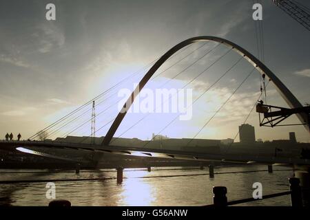 Die Millennium Bridge am Fluss Tyne in Newcastle. Es ist die erste rotierende Brücke der Welt und wurde von einem riesigen Kran in Platz gesetzt. Die Brücke besteht aus einem Paar von Stahlbögen und die Struktur kann gekippt werden, damit große Boote darunter segeln können. Stockfoto