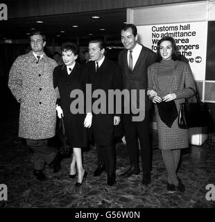 JUDY GARLAND 1964: Sängerin Judy Garland (2. L) und die Allan Brothers (beide Seiten von ihr) am Flughafen London. Miss Garland war gegangen, um den australischen Gesangsakt zu begrüßen, den sie bewältigen wird. Auch gab es Garlands Tochter, Liza Minnelli (18), und Mark Herron, Garlands Geschäftsführer. Stockfoto