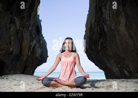 Junge Frau praktizieren Yoga am Strand von Motobu, Okinawa, Japan Stockfoto
