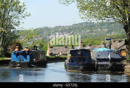 Ein Boot fährt entlang des Leeds und Liverpool Canal bei Five Rise Locks, Bingley, West Yorkshire, während das warme Wetter in ganz Großbritannien weitergeht. Stockfoto