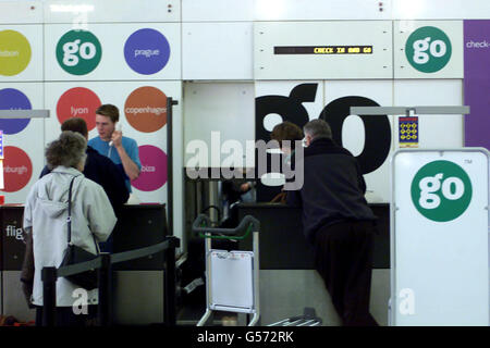 Passagiere stehen am Go-Check-in-Schalter in Stansted in Essex in der Warteschlange. BA hat seinen kostengünstigen Spediteur Go zum Verkauf angeboten und fügte hinzu, dass er mit schlecht abschneiden Teilen seines Geschäfts rücksichtslos handeln würde. *... Der Verkauf von Go am Flughafen Stansted wurde vom Billigflieger easyJet begrüßt, der immer behauptet hat, dass Go einen unfairen Vorteil hatte, indem es BA hinter sich hatte. Die Go-Entscheidung kam, als BA einen Gewinn vor Steuern von Juli bis September 2000 in Höhe von 200 Millionen ankündigte, was einer Steigerung von 400% gegenüber dem gleichen Zeitraum im Jahr 1999 entspricht. Stockfoto