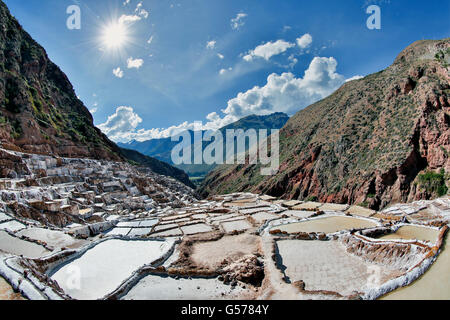 Salinen und Sunburst, Maras Salzbergwerk (Salineras de Maras), in der Nähe von Dorf Maras, Cusco, Peru Stockfoto