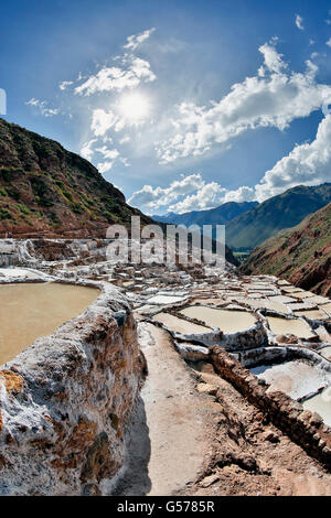 Salinen und Sunburst, Maras Salzbergwerk (Salineras de Maras), in der Nähe von Dorf Maras, Cusco, Peru Stockfoto