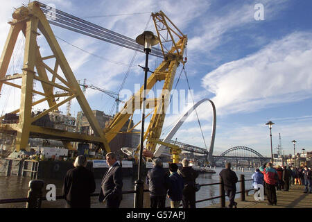 Der weltweit größte Schwebekran Asian Hercules II, bewegt die 850-Tonnen Gateshead Millennium Bridge den Fluss Tyne hinauf, in seine dauerhafte Position. Die 22 Millionen Brücke wird den Fluss Tyne überspannen, um eine Fußgänger- und Fahrradverbindung zu schaffen. * zwischen den Gateshead Quays und dem benachbarten Newcastle's Quayside. Das Design der Struktur ermöglicht es, sich zu drehen, damit Boote unter und die Bewegung der Brücke wurde mit dem Blinzeln eines Auges verglichen. Stockfoto