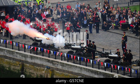 Ein Royal Salute wird vom nördlichen Ufer der Themse in der Nähe der Tower Bridge, London, abgefeuert, während der Diamond Jubilee River Pageant vorbeigeht. Stockfoto