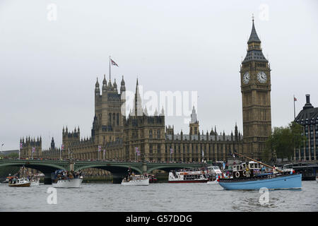 Boote passieren die Houses of Parliament, während sie während des Diamond Jubilee River Pageant in London in Richtung Tower Bridge entlang der Themse fahren. Stockfoto