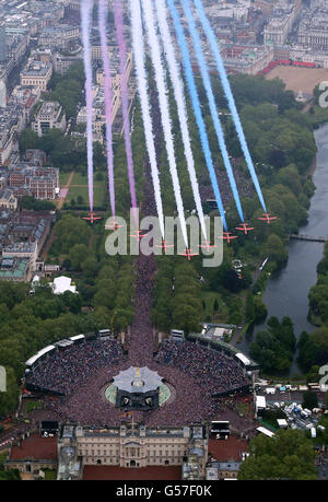 Die roten Pfeile fliegen in Formation über den Buckingham Palace in London, während die königliche Familie auf dem Balkon steht. Stockfoto