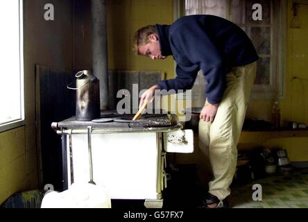 Prinz William überprüft die Flammen des Küchenofens in der Unterkunft des Teams an seinem Tag der Hausaufgaben im Dorf Tortel, Südchile, während seiner Raleigh International Expedition. Stockfoto