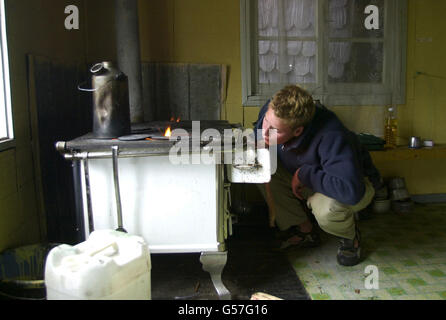 Prinz William fächzt die Flammen des Küchenofens in der Unterkunft des Teams an seinem Tag der Hausaufgaben im Dorf Tortel, Südchile, während seiner Raleigh International Expedition. Stockfoto