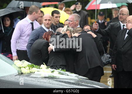 Freunde und Familie schließen sich den Trauernden an, um Blumen auf den Leichenwagen zu legen, der den Sarg des privaten Gregg Thomas Stone vom 3. Bataillon, des Yorkshire Regiments trägt, wie er und CPL Michael John Thacker, vom 1. Batalion, dem Royal Welsh (die Royal Welsh Fusiliers, passieren den Memorial Garden in Carterton, In der Nähe von RAF Brize Norton, Oxfordshire. Stockfoto