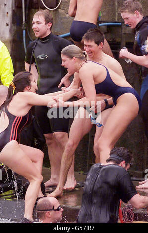 Schwimmer feiern nach dem 52. Jährlichen Schwimmen in Weymouth und Portland Christmas Day Harbour, das von lokalen Wohltätigkeitsorganisationen unterstützt wird. Stockfoto