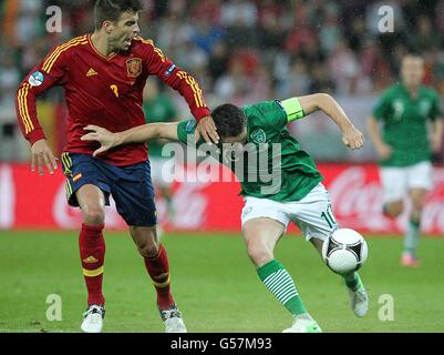 Fußball - UEFA Euro 2012 - Gruppe C - Spanien / Republik Irland - Arena Danzig. Robbie Keane (rechts) der Republik Irland und Gerard Pique (links) der spanischen Regierung kämpfen um den Ball Stockfoto