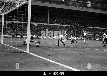 WM 1966: Der Ball entzieht sich den Händen des englischen Torhüters Gordon Banks und geht ins Netz, um Westdeutschland nach 13 Minuten im Weltcup-Finale im Wembley-Stadion einen 1-0-Vorsprung zu geben. Der Torschütze war Helmut Haller. * England Spieler auf dem Bild sind (l-r) Ray Wilson, Jackie Charlton und Bobby Moore. 7/3/01: Legendärer Torwart Banks wird seine WM-Siegermedaille 1966 versteigern. Der England-Star spielte in der Seite, die die ehemalige Westdeutschland 4-2 in Wembley zu schlagen, um den größten Preis des Fußballs zu gewinnen. Experten glauben, dass die Medaille zwischen 70,000 und 90,000 an der holen wird Stockfoto