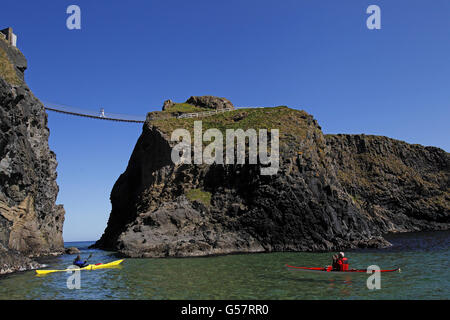 Die olympische Flamme wird von der Tragerin Clare Leahy über das berühmte Wahrzeichen der Carrick-a-Rede-Seilbrücke außerhalb des Dorfes Ballintoy, Co.Antrim getragen. Stockfoto