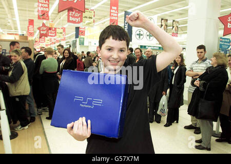 Joe Jones, 14 Jahre alt, präsentiert sein neues PlayStation 2-System im Kingston Park Tesco Store in Newcastle. Joe stand sechs Stunden in der Schlange und war der erste, der eine der neuen Spielkonsolen im Laden bekam. Stockfoto