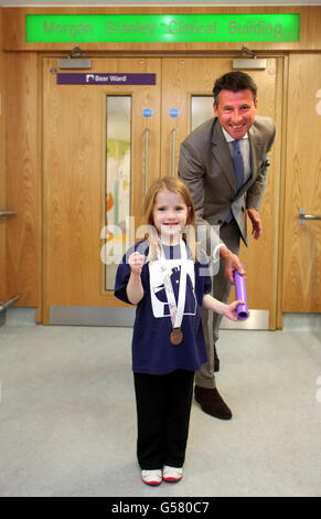 Lord Coe übergibt der Herzpatientin Sarah Cox Five während der Eröffnung des neuen Morgan Stanley Clinical Building im Londoner Great Ormond Street Hospital, dem ersten Teil des Mittal Children's Medical Center, einen Stab. Stockfoto